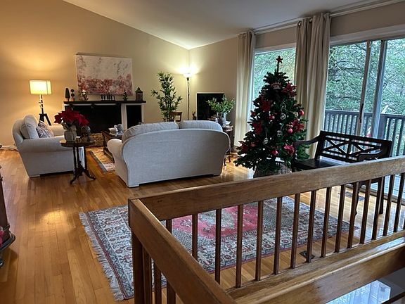 Spacious Living Room (27'x15'), with cathedral ceilings, wood burning fireplace and direct access to front balcony