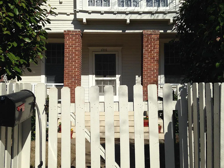 Front of house with fully fenced yard.