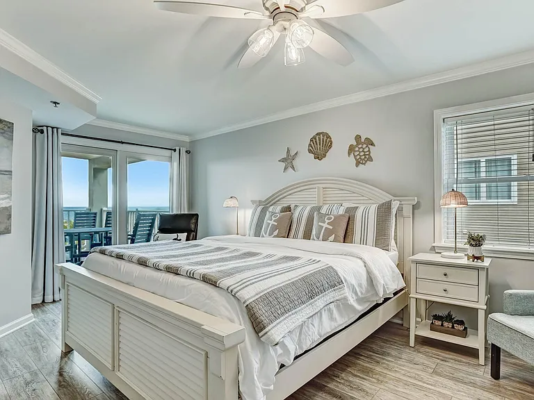 Primary bedroom with king size bed and access to balcony.
