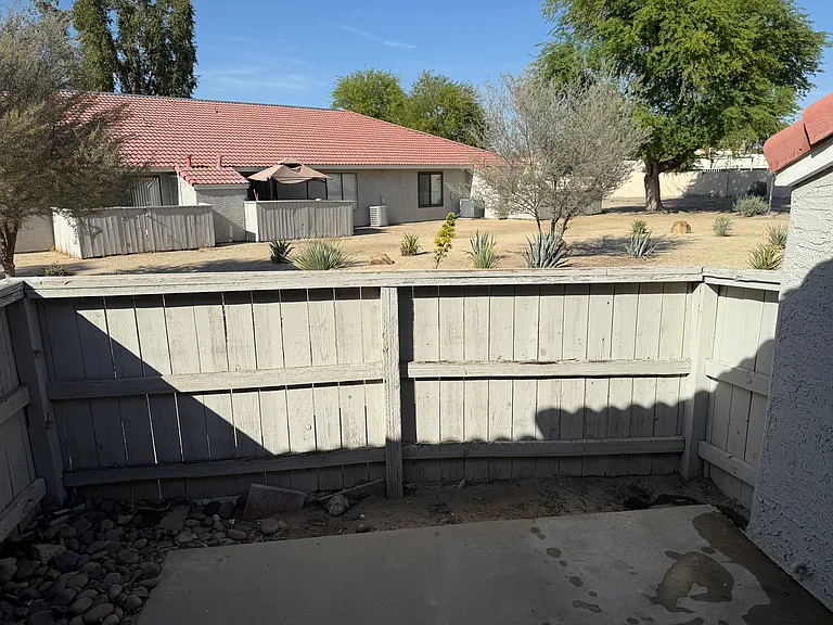 Fenced rear patio with slab for table & cheirs.