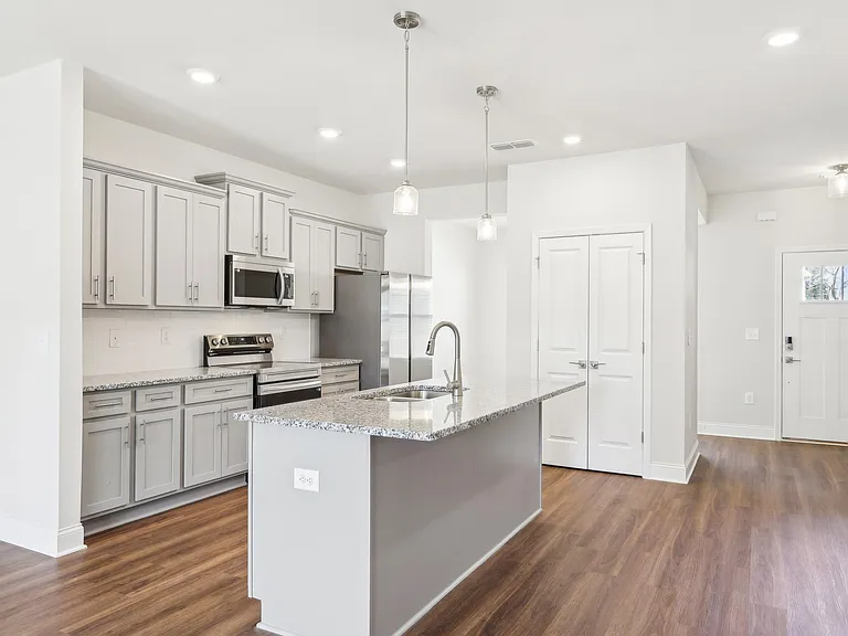 Sleek kitchen with white cabinetry and granite countertops.