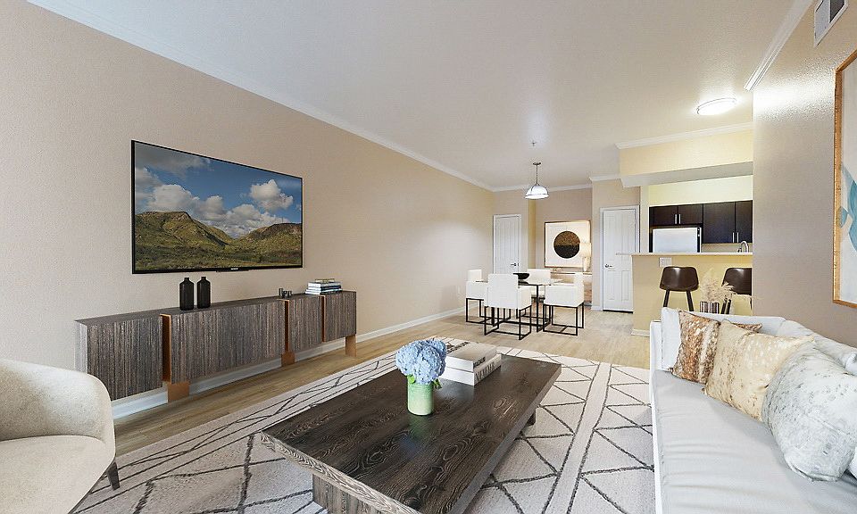Staged living and dining area with hardwood style flooring. Kitchen with stainless steel appliances.