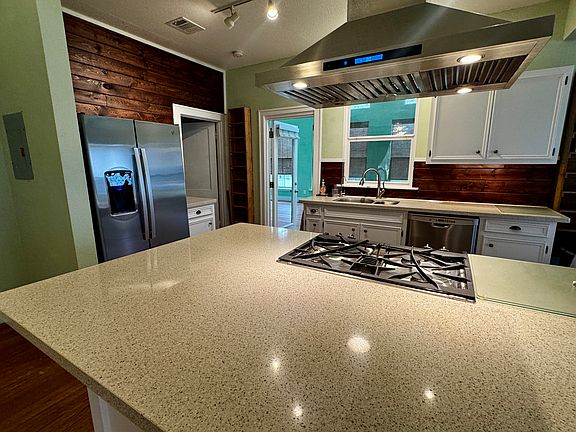 Kitchen island, range, vent hood, sink. dishwasher, fidge