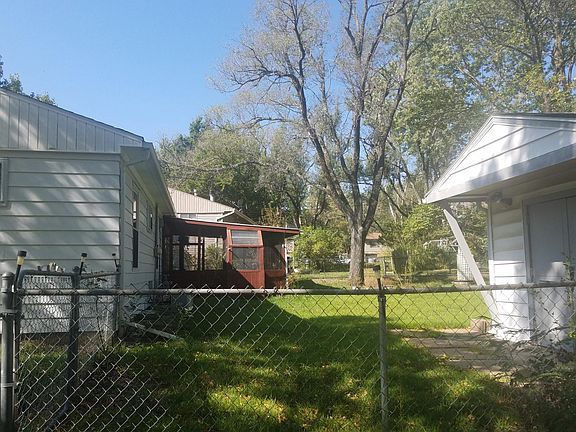 fenced yard with shed and screened patio with gas grill