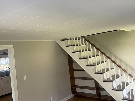 living room, bookcase niche under stairs