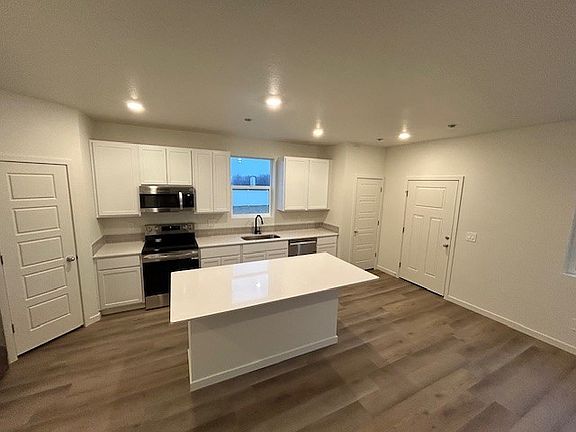 Kitchen with large island, easily fits 3 barstools on either side.
