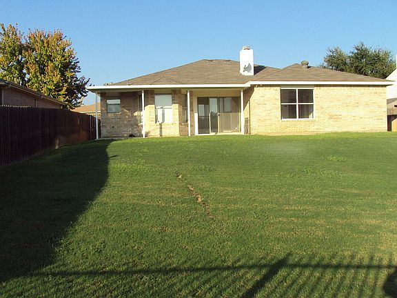 View of Home from Rear Fence Line
						:
						Sprinkler system to help keep it green.