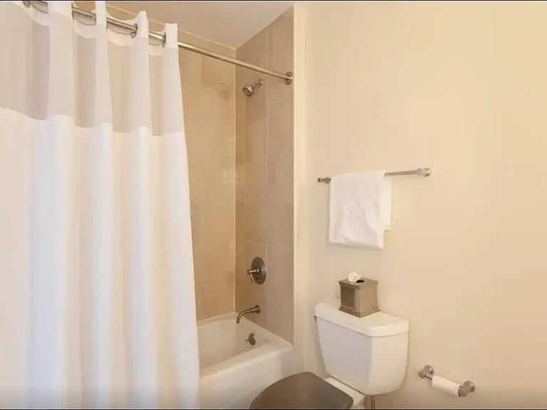 shower with marble tile on wall and floor