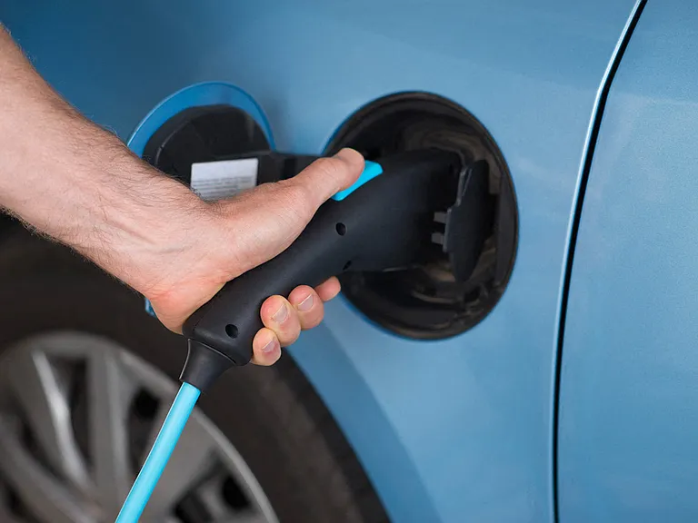 Controlled access parking garage with car charging stations