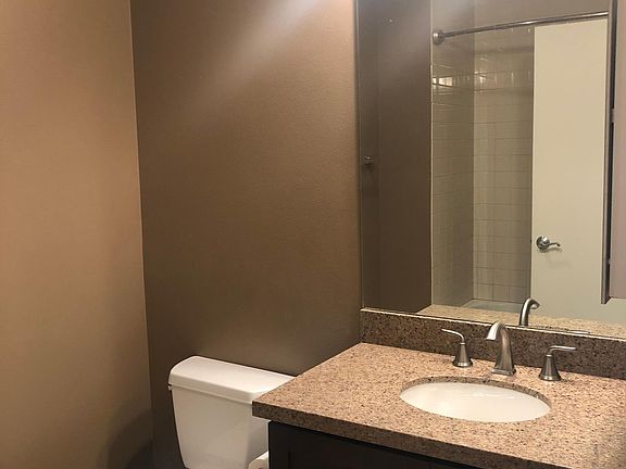 Full Bath with granite countertops, dark wood cabinets, & tile floors