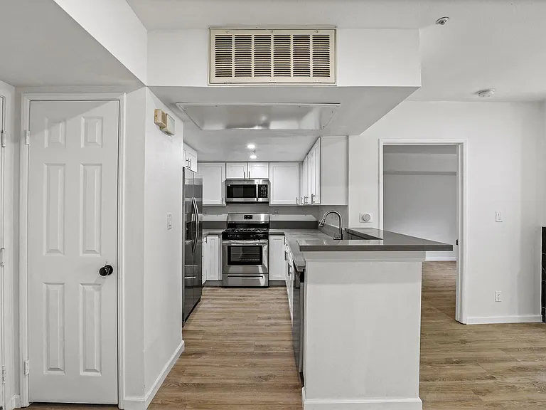 Front Entrance of Apartment with a Hall Closet, and an Open-Concept Kitchen with Energy-Efficient Appliances