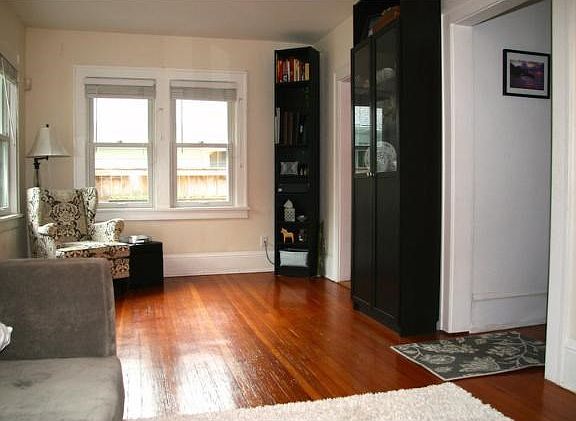 Gleaming hardwood floors are in the formal living room. A light and bright room.