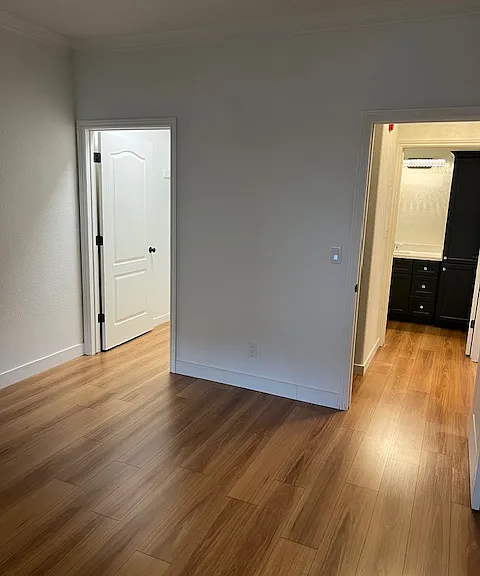 looking from the window on lewist st towards the walkin closet on the left and the bedroom door to the hallway and to the bathroom across