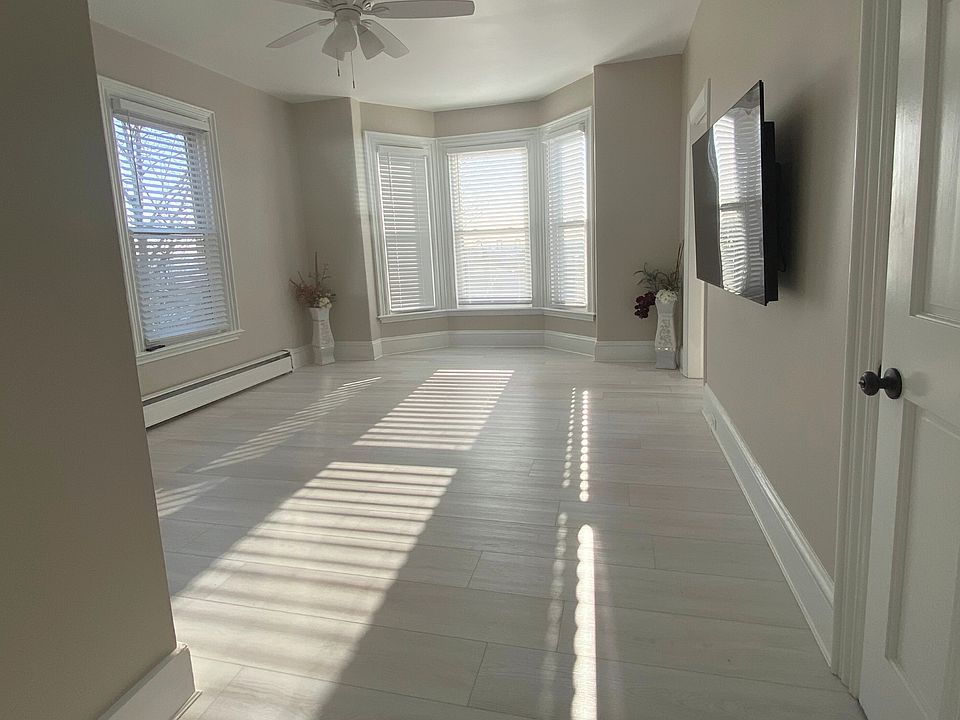 A bright, welcoming living space with brand-new flooring, natural light throughout the day, and a convenient secondary entry option.