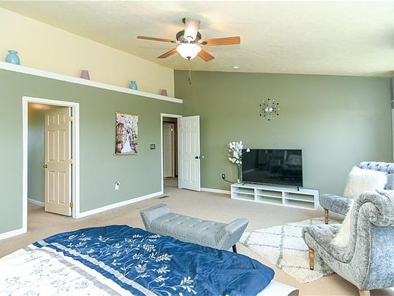 Master bedroom with mantel for decorations and also a ceiling fan.