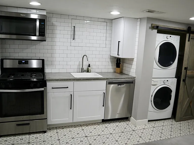 newly remodeled kitchen with microwave, gas stove, dishwasher, full size refrigerator and washer and dryer
