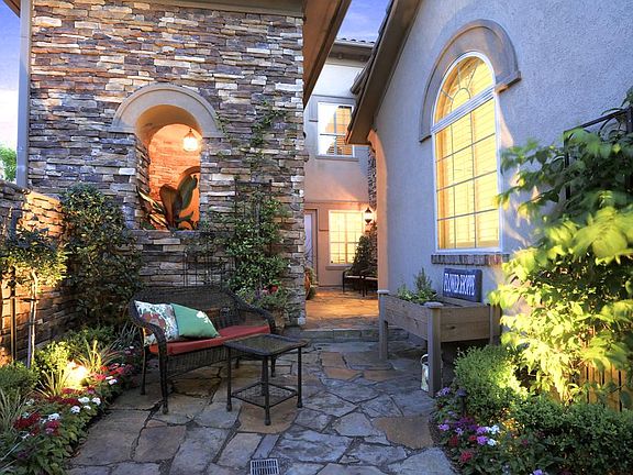 Welcome home to this secluded courtyard entry offering 2 seating areas and lush landscape