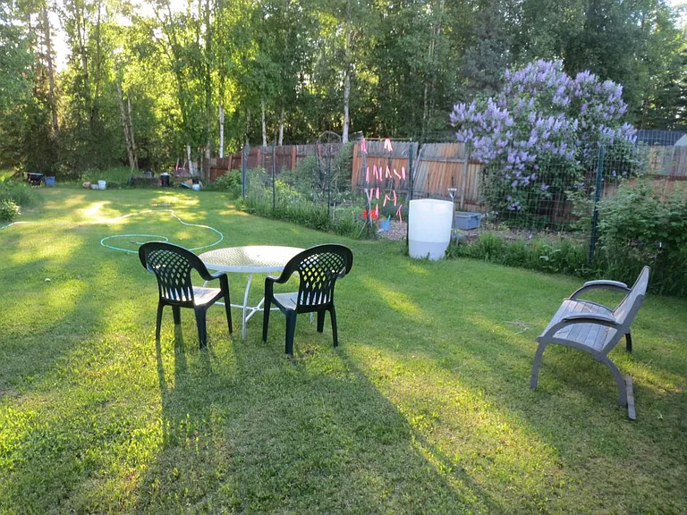Back yard with gardens, compost area, lilac bush, raspberries and dining. We all pitch in with mowing.