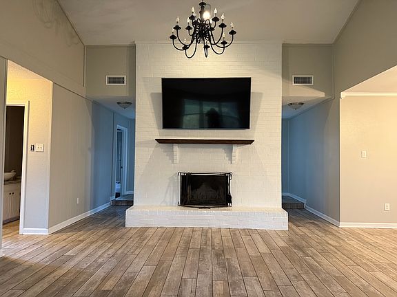 living room with 65" tv included and wood burning fireplace