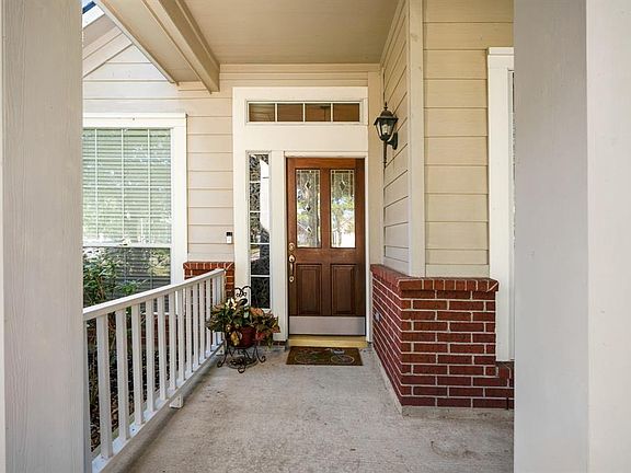 Welcoming covered front porch with protective rail, ideal place to sit and wait for the kids to get off the school bus, and for the delivery of parcels.