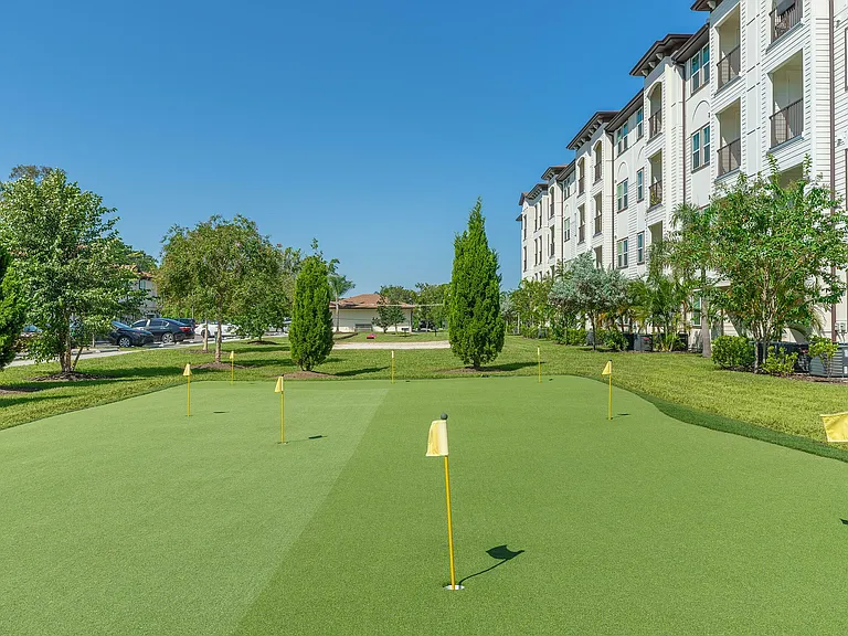 Experience luxury living with a private putting green surrounded by vibrant greenery.