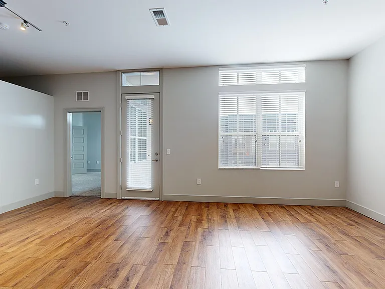 Apartment dining and living room with wood-style flooring.