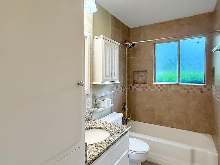 Bathroom with built-in storage and updated tile and granite.