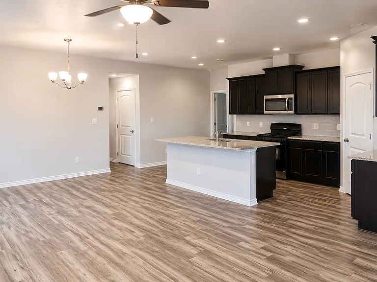 Modern kitchen with granite island and dark cabinetry