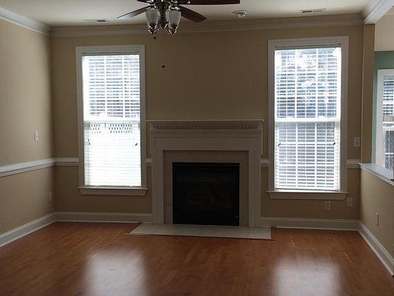 Ample but cozy den with fireplace overlooking backyard