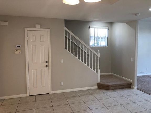 Tile entry. Brand new carpet on stairs (not shown) and light plank flooring to right of stairwell (living room)