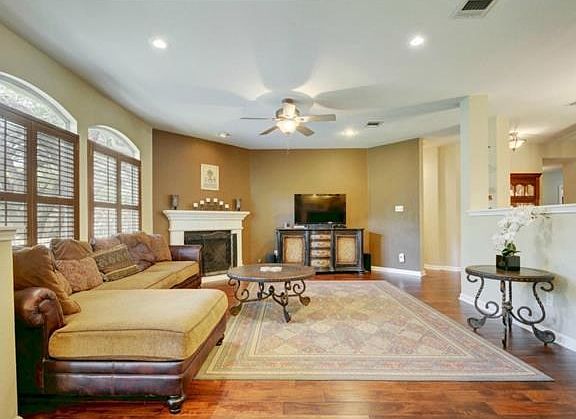 Living room has cozy fireplace and shutters on windows.
