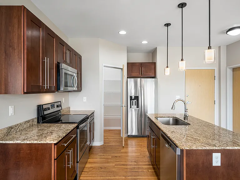 Modern kitchen with elegant granite countertops, stainless steel appliances, and sleek wooden cabinetry, perfect for culinary enthusiasts. Modern kitchen with elegant granite countertops, stainless steel appliances, and sleek wooden cabinetry, perfect for