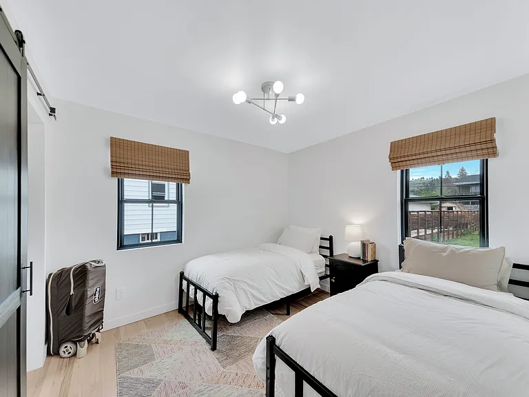 The secondary bedroom on the main floor contains two single beds, a large closet and a nightstand for storage.