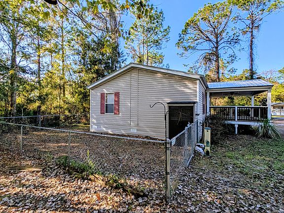 Showing view from side of property for another view of fenced back yard.
