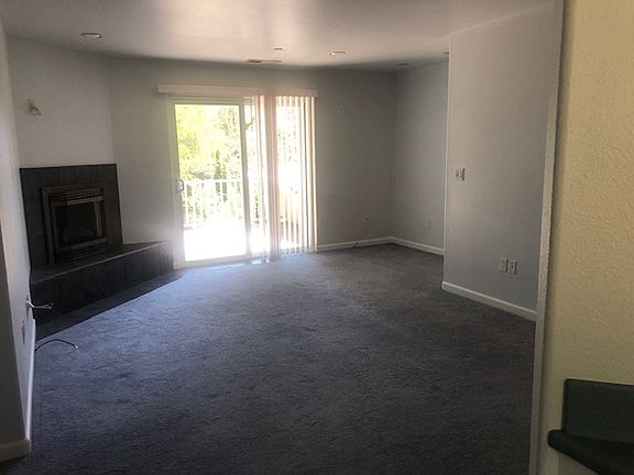 Linving room with fireplace and sliding door out to the back deck