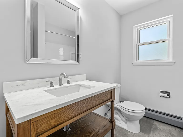 The second full bathroom blends charm and modern updates with a custom vanity featuring warm wood details.