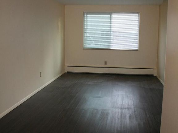 large windows in living area open to private parking and adj