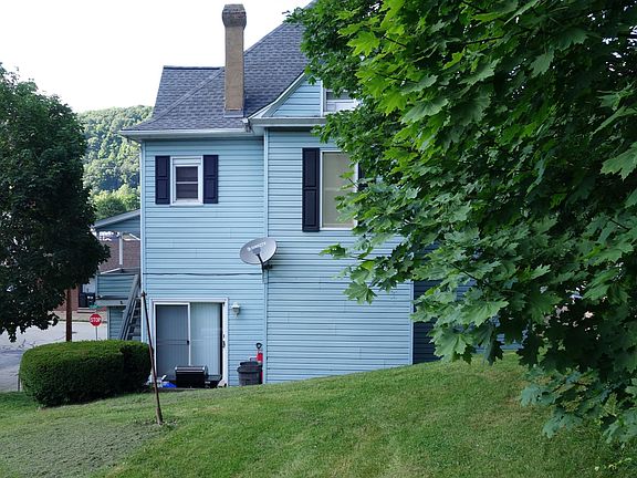 Rear of property includes a shared backyard. Backyard has dedicated off-street carport (stone/gravel) for two vehicles.