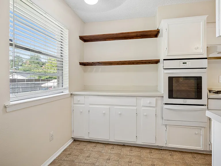 Breakfast area with wood shelves and more cabinets below the bar top