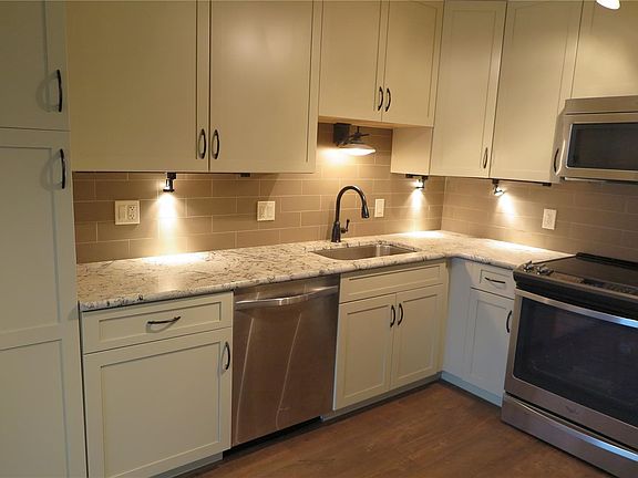 The new kitchen features 42 inch off white cabinets.  Notice the large pantry and subway tile back splash