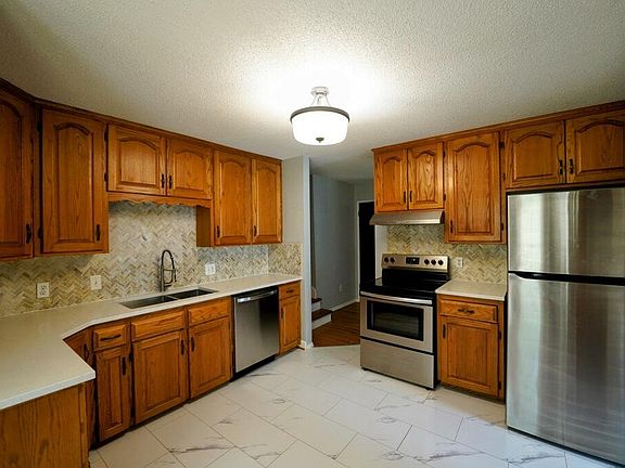 Kitchen with all new appliances, sink, quartz countertops and tile backsplash.
