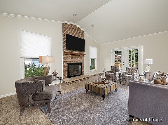 Cathedral ceiling. Recessed lights over brick wood burning fireplace with gas stater. Crown molding.