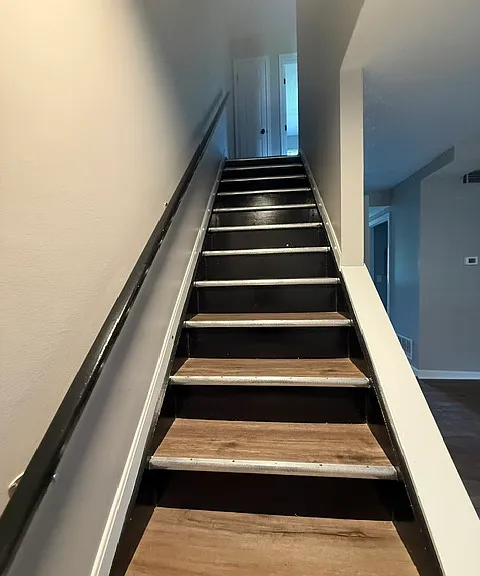 Staircase in living room headed to the upstairs bedrooms and bathroom