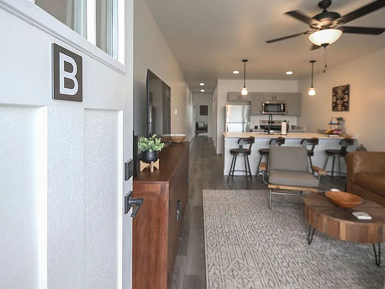 Inviting open-concept apartment with modern kitchen and cozy living area, perfect for relaxation and entertaining.
