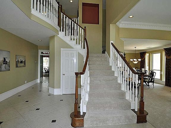 View of double sided stairway. Full storage located under entire stairway area! Plush brand new carpet in every room that does not have tile upstairs & down!!