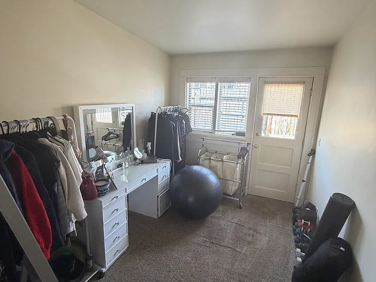 small back bedroom with no closet and a door to the back area.