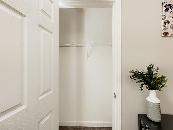 Spacious walk-in closet with a full-length shelf and hanging rod, offering convenient storage and easy organization.