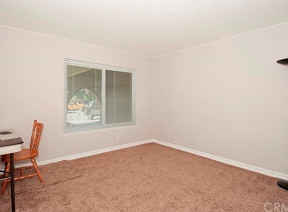 Secondary bedroom looking to the front of the home. New carpet, paint and vinyl window
