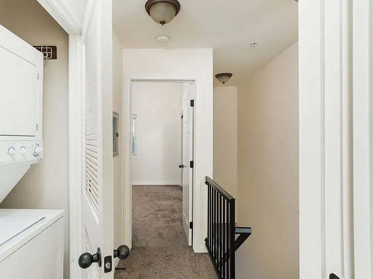 Full size stacked washer and dryer in bedroom hallway at The Nines Townhomes in Escondido, California.