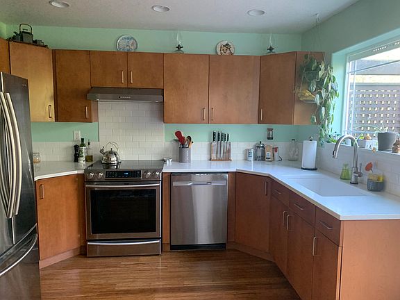 Bright and sunny kitchen with new appliances and induction stovetop.